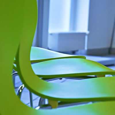 Wartebereich der Praxis mit grünen Sitzbänken